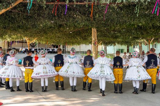 Rakvice, Czech Republic - June 2021. Beautiful women and men dancers in a celebration.Traditional Moravian feast. Young people in parade dressed in traditional Moravian folk costume.