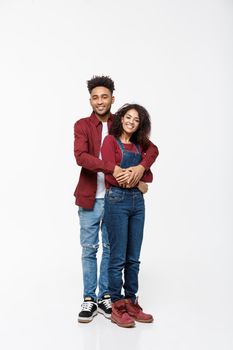 Full body portrait of young African American hugging couple, with smile. Dating, flirting, lovers, romantic studio concept, isolated on white background