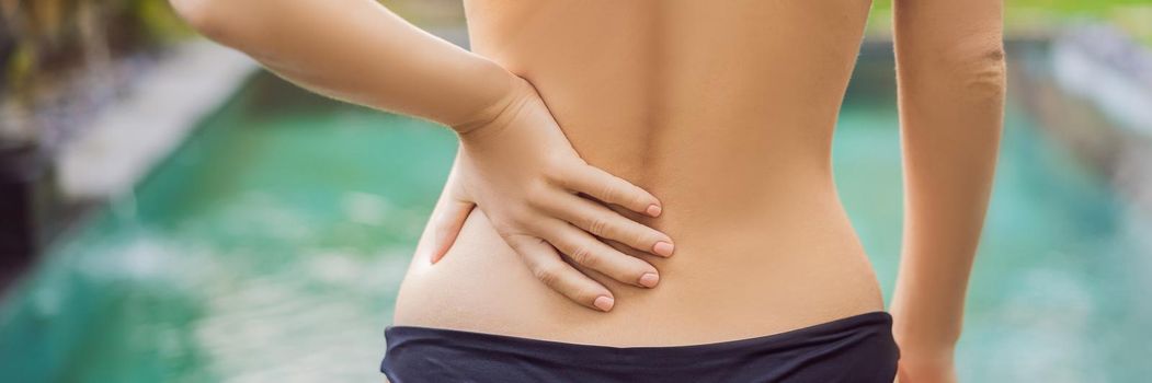 Women's back hurts against the backdrop of the pool. Pool helps with back pain. BANNER, LONG FORMAT