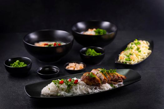 Various dishes of Asian cuisine with different types noodles and rice with shrimp, vegetables and black sesame