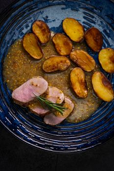 pork tenderloin with baked potatoes and French coarse mustard sauce