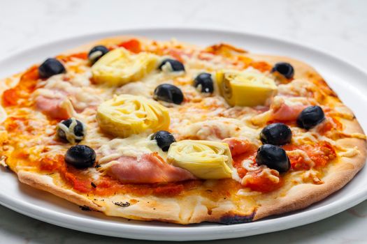 pizza with ham, black olives and artichokes
