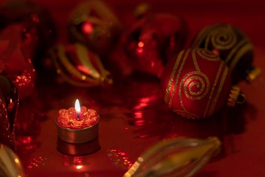 Christmas still life with red baubles and candle