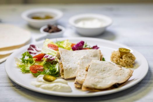 chicken quesadilla with rice, beans, salad, chalapenos and salsa