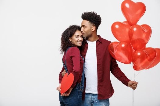 Young attactive African American couple holding heart balloon and paper