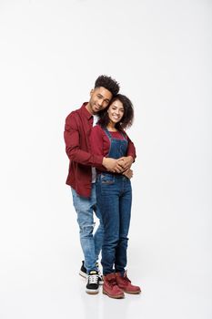 Full body portrait of young African American hugging couple, with smile. Dating, flirting, lovers, romantic studio concept, isolated on white background