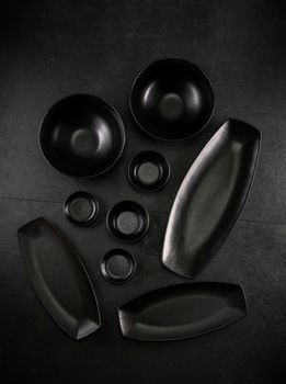 black plates and bowls on a black background