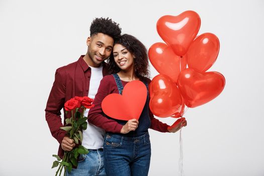 Young attractive african american couple on dating with red rose,heart and balloon