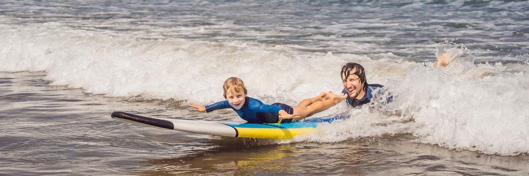 BANNER, LONG FORMAT Father or instructor teaching his 5 year old son how to surf in the sea on vacation or holiday. Travel and sports with children concept. Surfing lesson for kids.