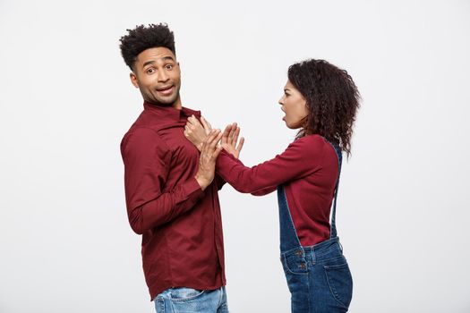 Unhappy African American couple in casual clothes arguing and figthing