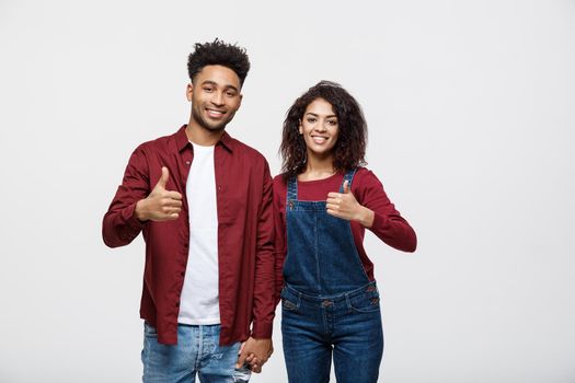 Portrait of attractive African american couple showing thumb up over white studio background