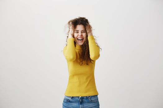 Portrait of beautiful cheerful redhead girl with curly hair smiling laughing looking at camera over white background