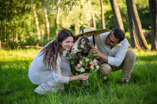 Groom in a stylish suit and bride in a beautiful vintage dress, married couple walking in the field at sunset on their wedding day. Kissing, having fun, dancing, happily ever after