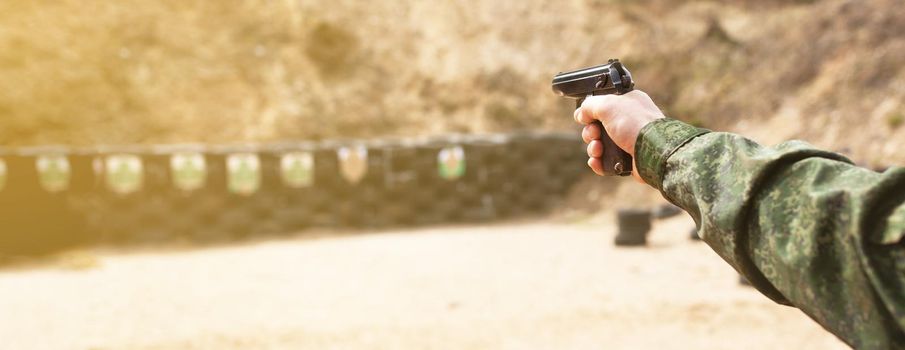 A military man in uniform. Man's hand with a gun