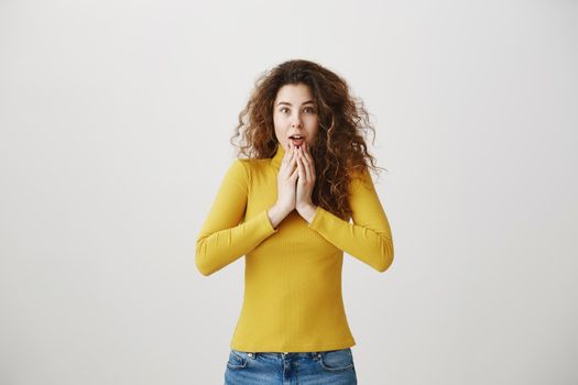 Portrait excited surprise young woman standing isolated over white background. Looking camera