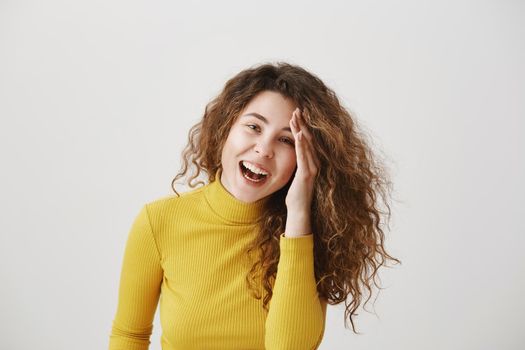 Portrait of beautiful cheerful redhead girl with curly hair smiling laughing looking at camera over white background