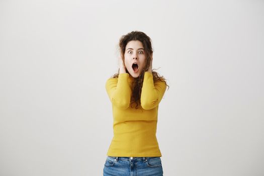 Portrait excited screaming young woman standing isolated over white background. Looking camera