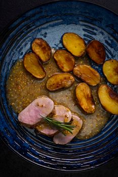 pork tenderloin with baked potatoes and French coarse mustard sauce