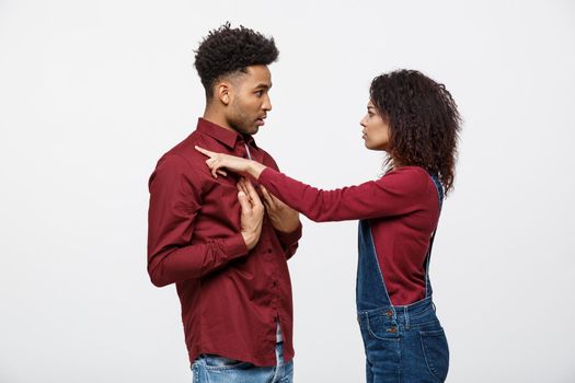 Unhappy African American couple in casual clothes arguing and figthing