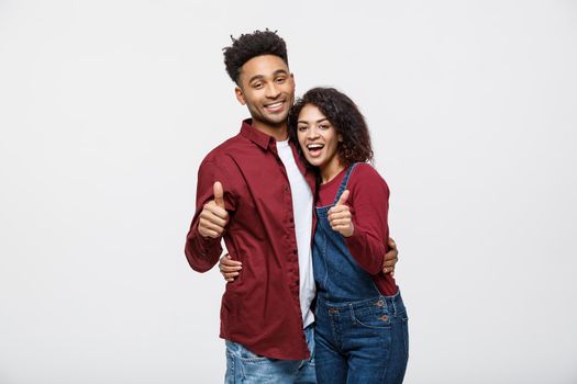 Portrait of attractive African american couple showing thumb up over white studio background