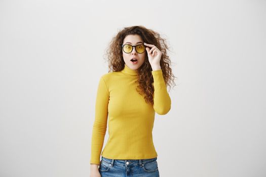 Portrait excited surprise young woman standing isolated over white background. Looking camera