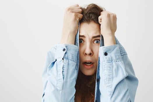 Portrait of displeased upset angry female, being discontent and unhappy, isolated over grey studio background