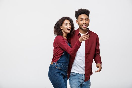 Young African American people in casual clothes looking away and point finger. isolated on white background.