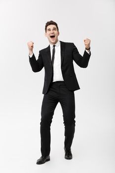 Business Concept: Full-length Portrait excited handsome business man with arms raised in success. Isolated on grey background