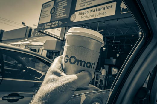 Puerto Aventuras Mexico 04. February 2022 Old black and white picture Mexican GOmart coffee holding in the car while driving in Puerto Aventuras Quintana Roo Mexico.