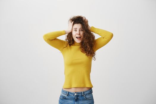 Portrait excited screaming young woman standing isolated over white background. Looking camera