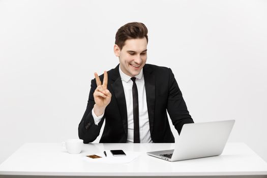 Young businessman facetime with someone and showing two finger or victory finger sign.