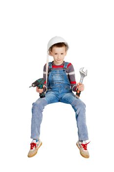 Boy builder fitter in helmet with tools in hands