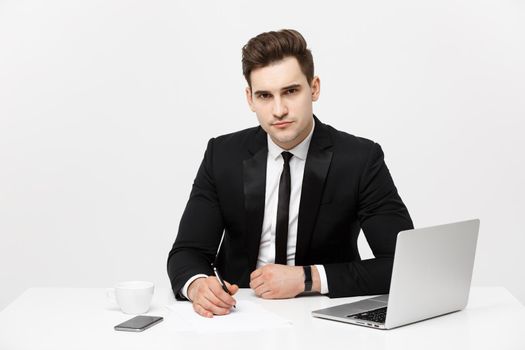 Portrait of confident manager sitting at desk and looking at camera. Portrait of business man working at computer. Successful formal man in his new modern office