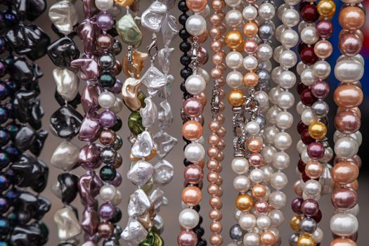 Various colorful beads in the market. Wallpaper background of a colorful necklace made of precious stones and colored beads. Semi-precious jewelry.