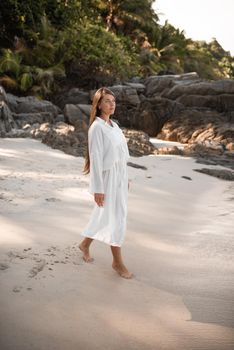 european young tan women have rest and run on white sand beach. long black chestnut hair . white cotton clothes. boho style dress.Thailand. Aquamarine crystal sea