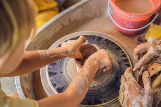 Father and son doing ceramic pot in pottery workshop.