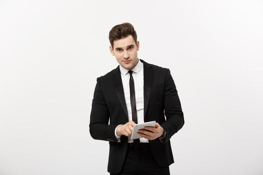 Checking statistics. Successful and confident businessman stands and checks online news on the tablet inside business center. Young business in formal suit