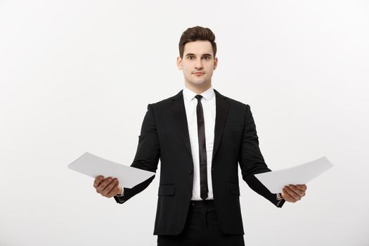 Business Concept: Attentive handsome businessman working comparing paper report. Isolated over white grey background