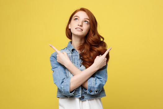 Lifestyle Concept: Happy excited cuacaisan tourist girl pointing finger on copy space isolated on golden yellow background.