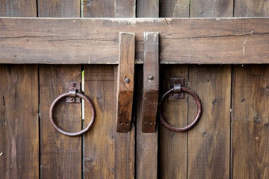 vintage door knobs on the door. ancient pens in the form of rings from metal. close up.