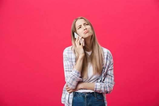 Bored girl calling on the phone and looking crazy on a pink background.