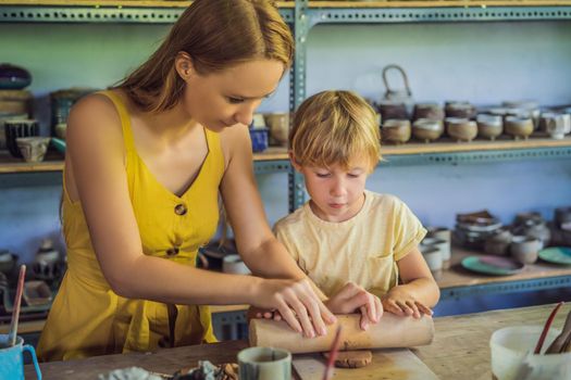 mother and son doing ceramic pot in pottery workshop.