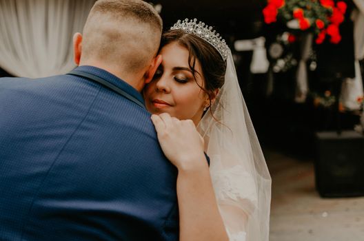 groom in suit and bride in dress in veil tiara dance together their first wedding dance. Slavic Ukrainian Russian traditions