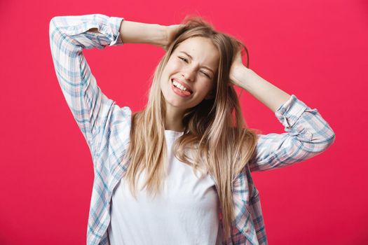 Gorgeours young Caucasian woman with healthy clean skin and beautiful set of features over pink background looking at camera with shy charming smile