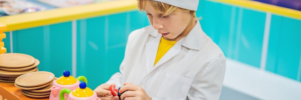 Boy plays the game as if he were a cook in a children's kitchen. BANNER, LONG FORMAT