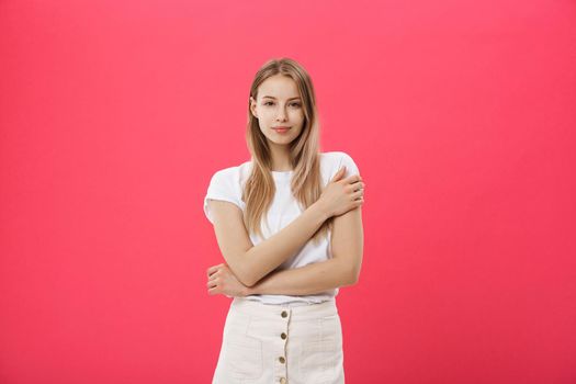 Trendy young female wearing casual clothes posing over pink background.