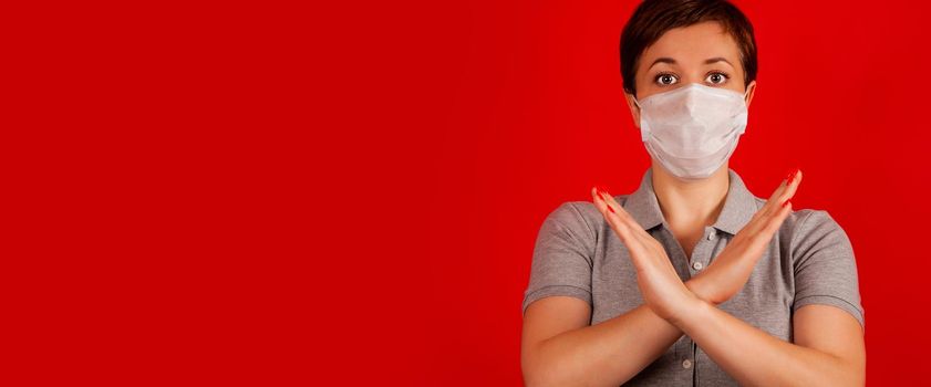 A woman in a mask indicates stopping the spread of the COVID-19 virus. The concept of preventing the spread of the epidemic and treating coronavirus. Coronavirus treatment.