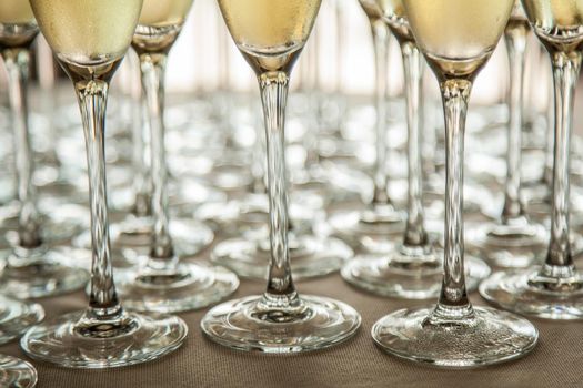 Legs of glasses with cold champagne