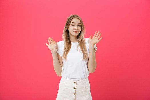 Displeased female model with freckled skin, raises eyebrows and frowns face, makes refusal gesture, says No. Discontent European woman indoor.