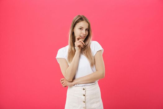 Trendy young female wearing casual clothes posing over pink background.